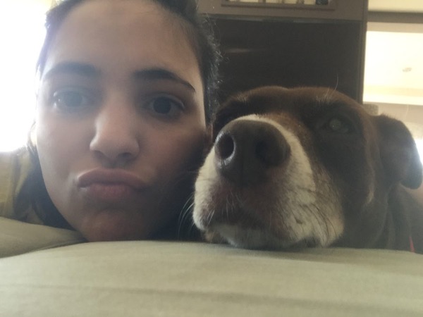 Carolina accanto a un cane anziano marrone e bianco che riposa
