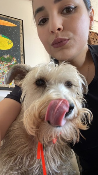 Carolina, pet sitter a Milano, tiene in braccio un cane dal pelo chiaro